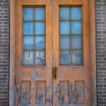 A rustic vintage wooden door with a brick surround; perfect for architectural themes.